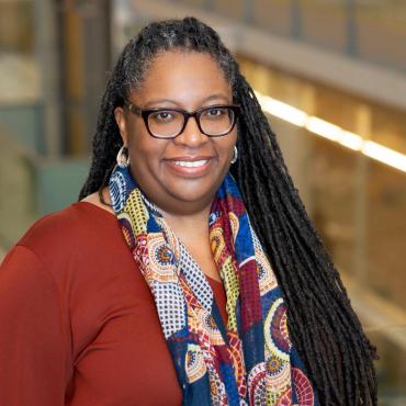 Sherrie Fernandez-Williams, a fifty-year-old black woman writer with dreadlocks smiling at the camera